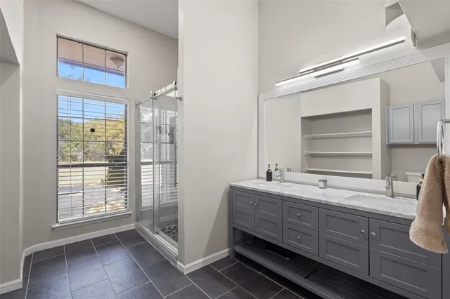 a bathroom with a double vanity sink a mirror and a bathtub