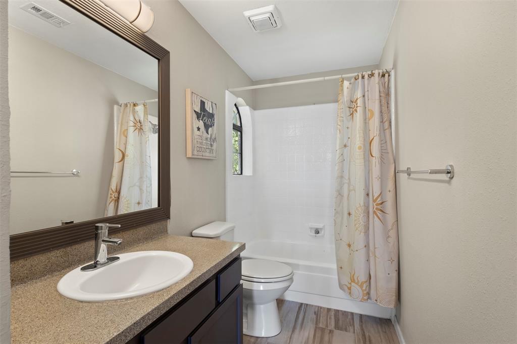 420 Seminary Ridge Mesquite, TX 75149 - Photo 22 of 36 a bathroom with a granite countertop sink toilet a mirror a vanity and shower