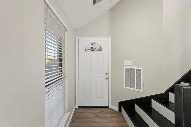 a view of a hallway with entryway and stairs
