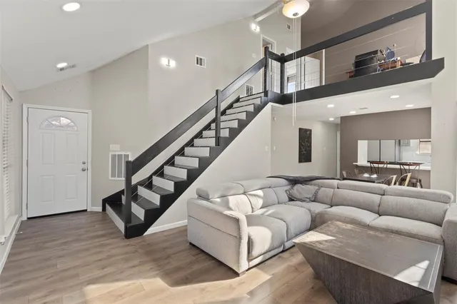a living room with furniture or stairs and a wooden floor
