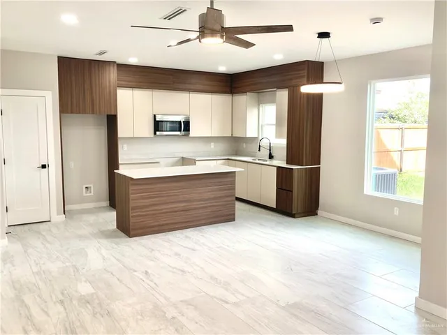 a kitchen with kitchen island cabinets and stainless steel appliances