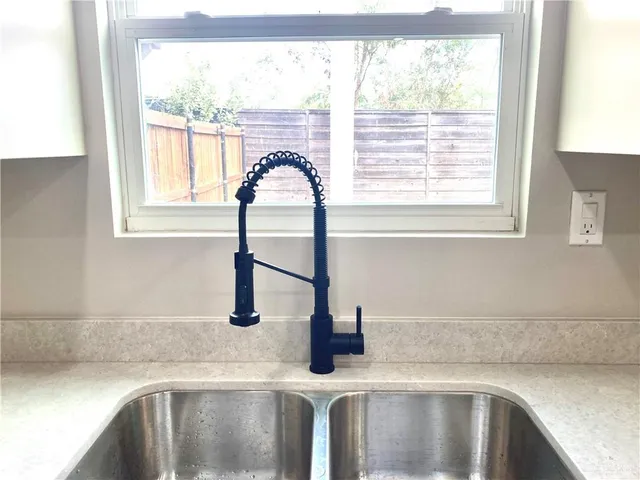 a kitchen with stainless steel appliances a sink window and cabinets