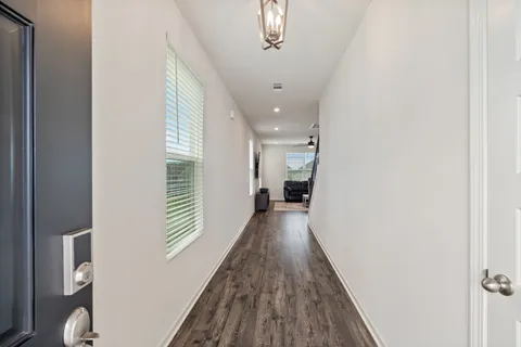 a view of a hallway with wooden floor and staircase