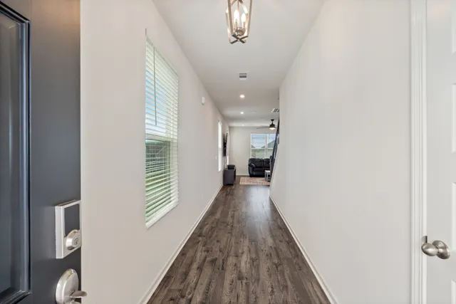 a view of a hallway with wooden floor and staircase