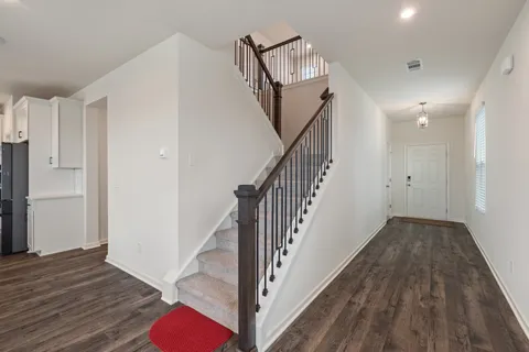 a view of a hallway with wooden floor and staircase