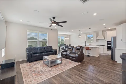 a living room with furniture and a wooden floor