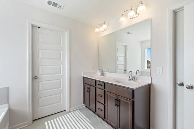 a bathroom with a tub shower and sink