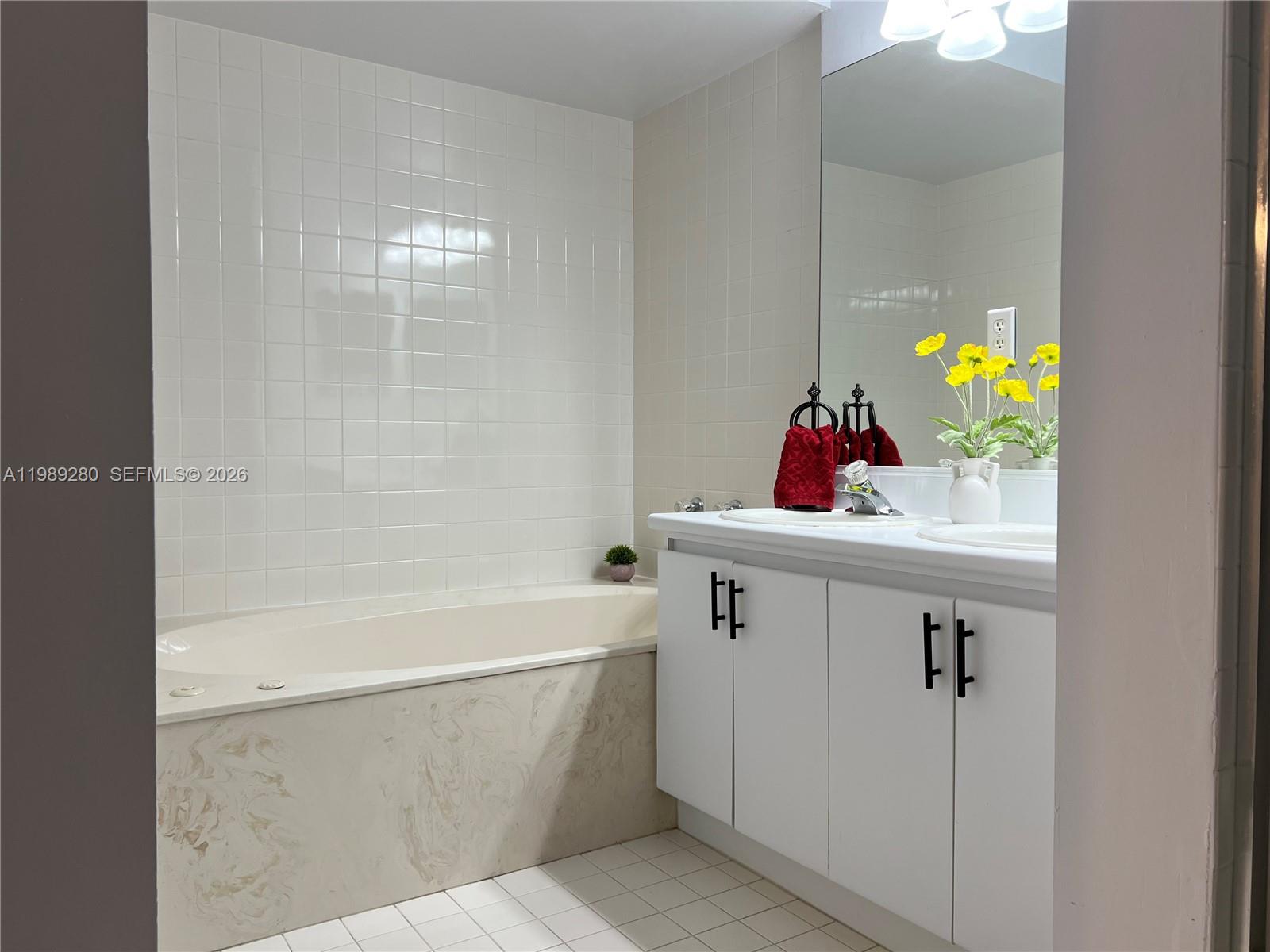 543 Racquet Club Road, Unit 33 Weston, FL 33326 - Photo 20 of 28 a bathroom with a bathtub sink and mirror