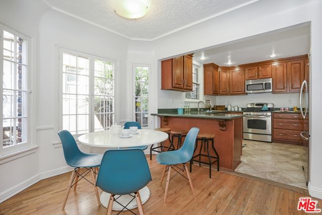 a kitchen with stainless steel appliances granite countertop a stove a sink a microwave dining table and chairs