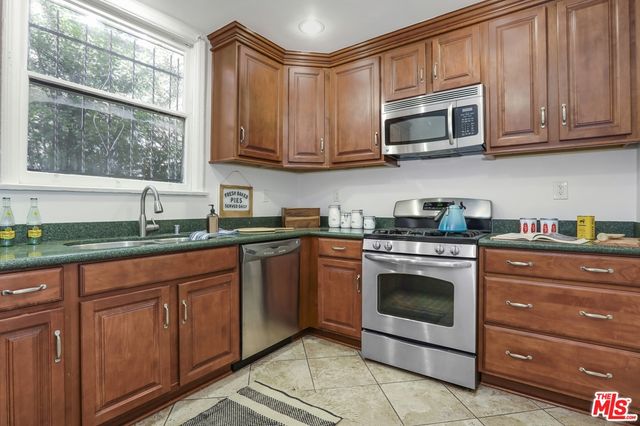 a kitchen with granite countertop a stove top oven microwave and cabinets