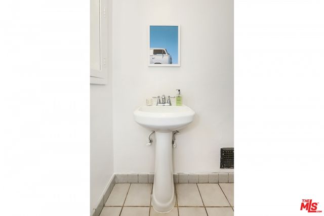 a bathroom with a sink a mirror and a potted plant