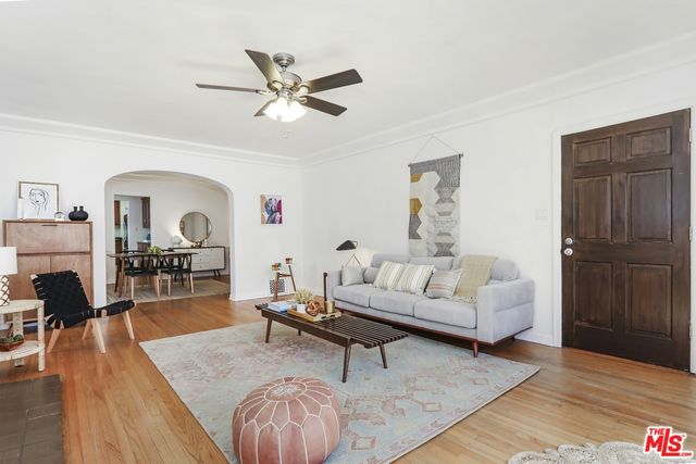 a living room with furniture and a wooden floor