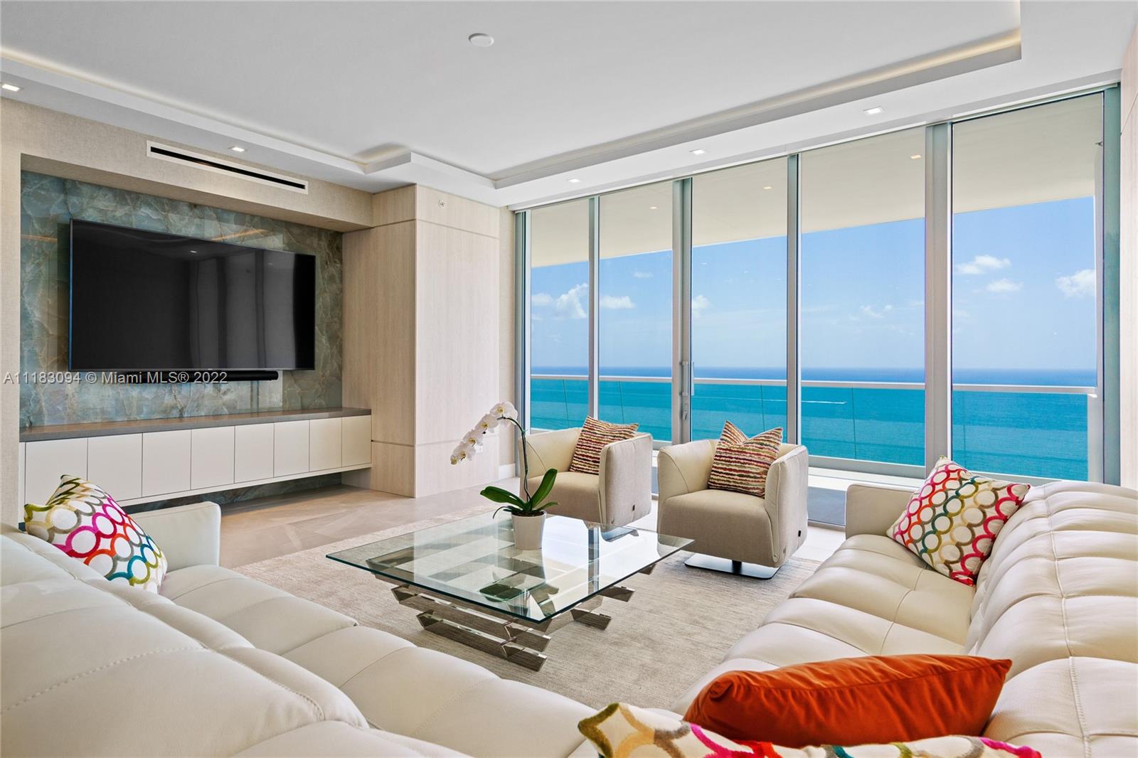 18501 Collins Avenue, Unit 3302 Sunny Isles Beach, FL 33160 - Photo 11 of 48 a living room with furniture and a flat screen tv