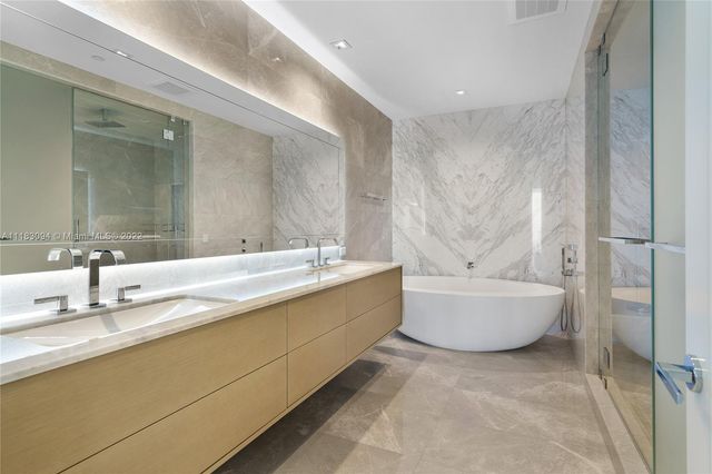 a bathroom with a bathtub sink mirror and toilet
