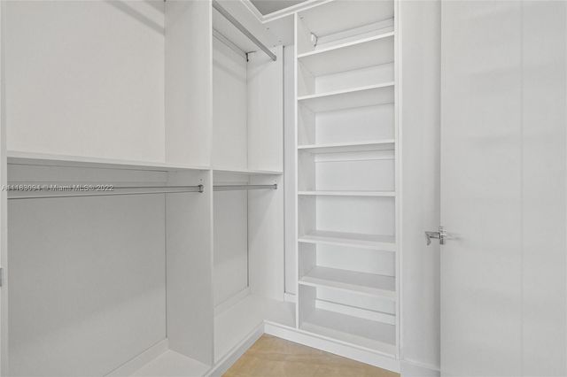 a view of walk in closet with empty racks