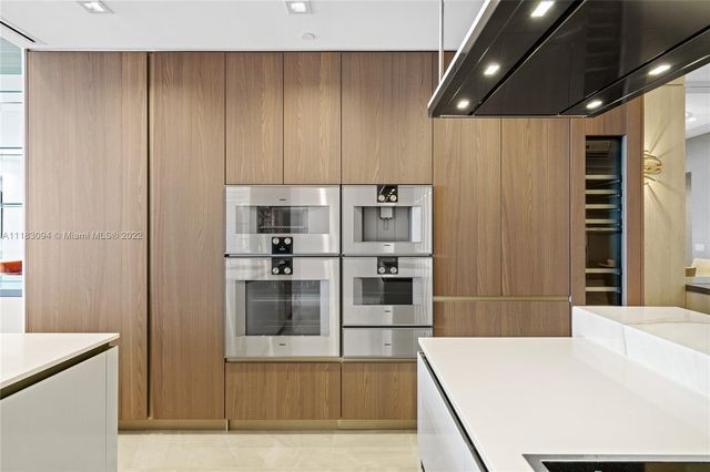 a large kitchen with stainless steel appliances a refrigerator and a stove