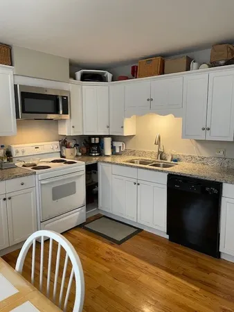 a kitchen with granite countertop a sink stainless steel appliances and cabinets