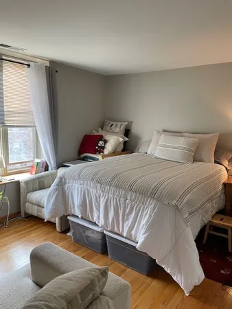 a bedroom with a bed couch and window