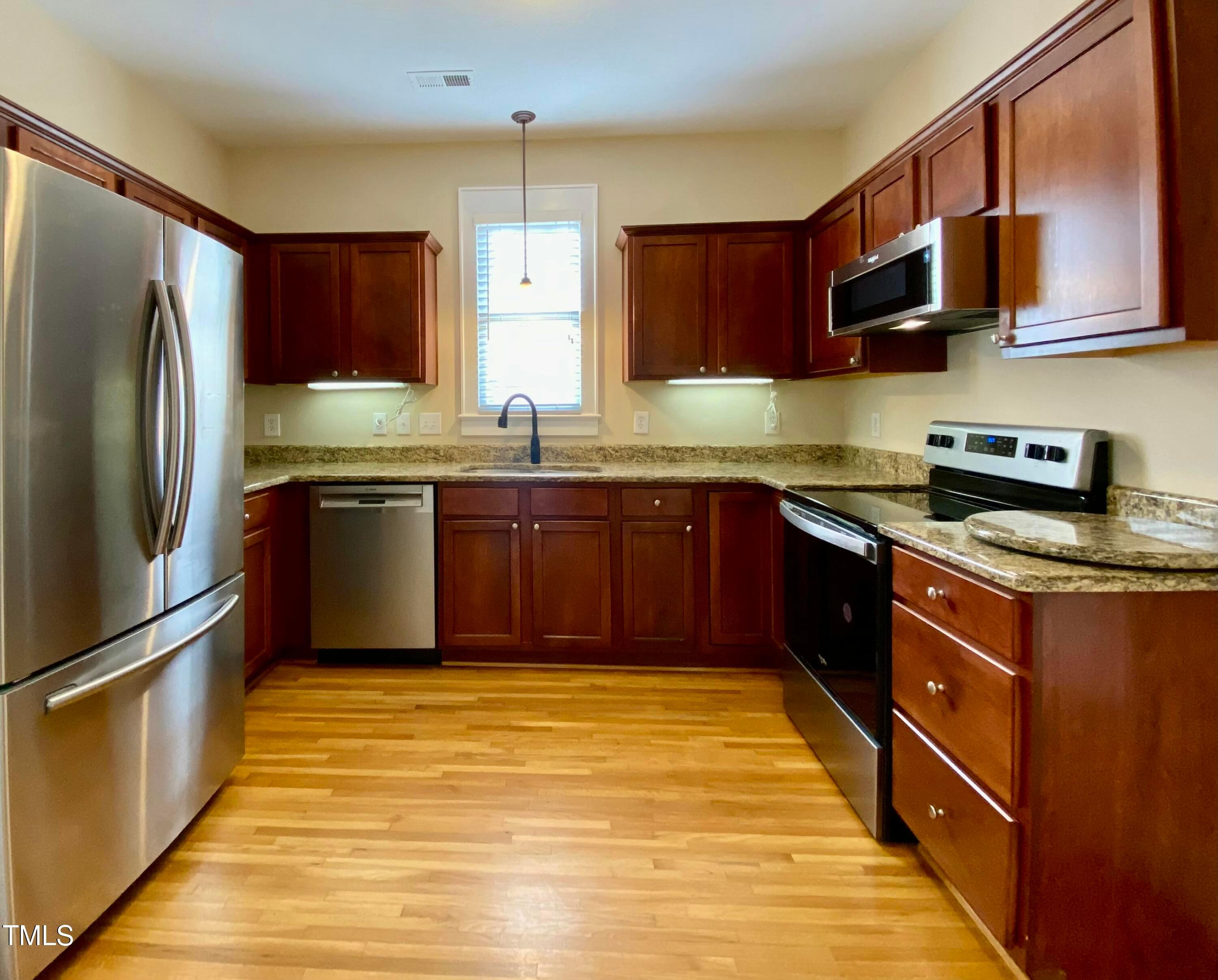 813 Clarendon Street Durham, NC 27705 - Photo 11 of 36 a kitchen with stainless steel appliances granite countertop a sink a stove top oven a refrigerator and dishwasher