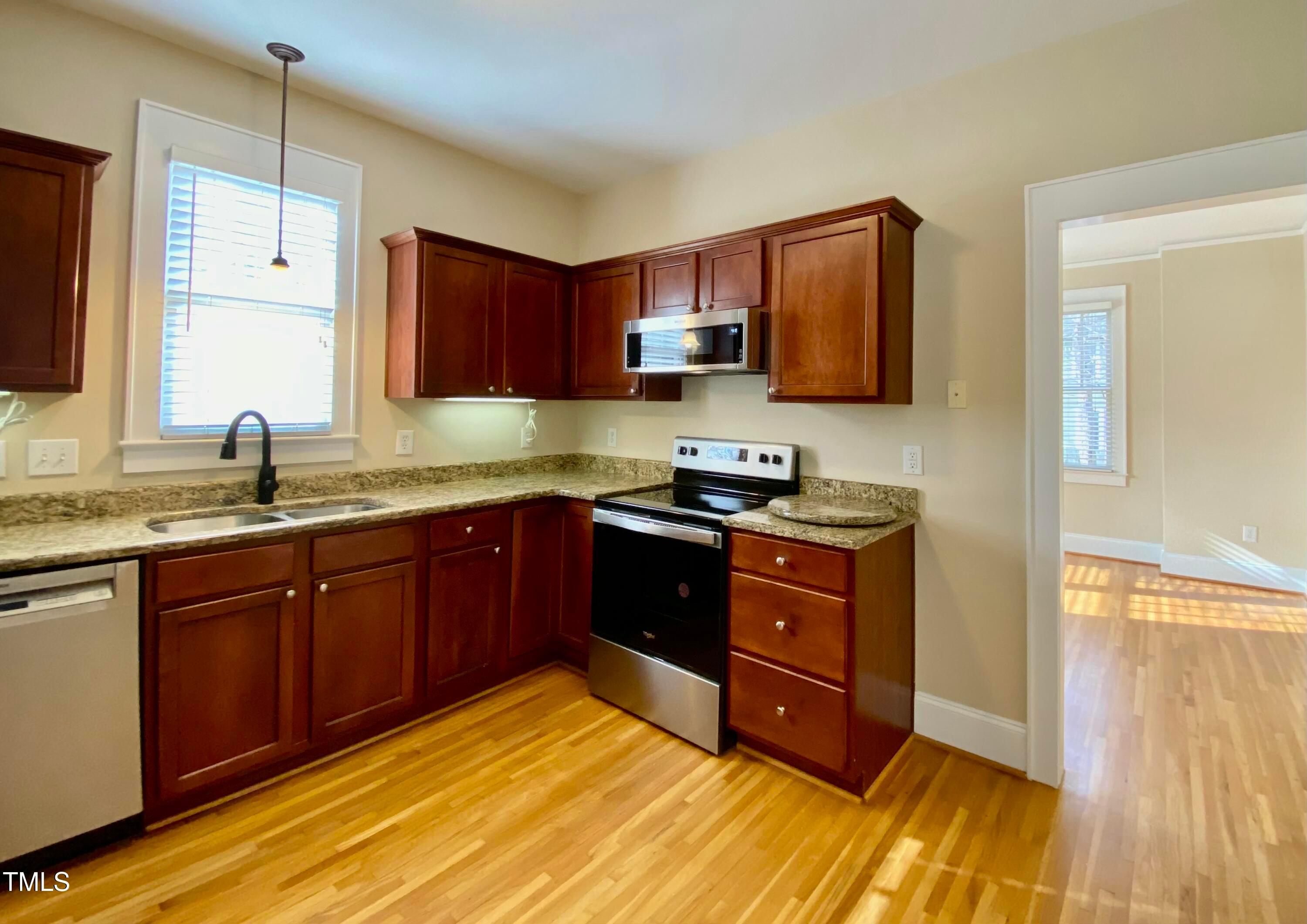 813 Clarendon Street Durham, NC 27705 - Photo 13 of 36 a kitchen with stainless steel appliances granite countertop a sink stove and cabinets