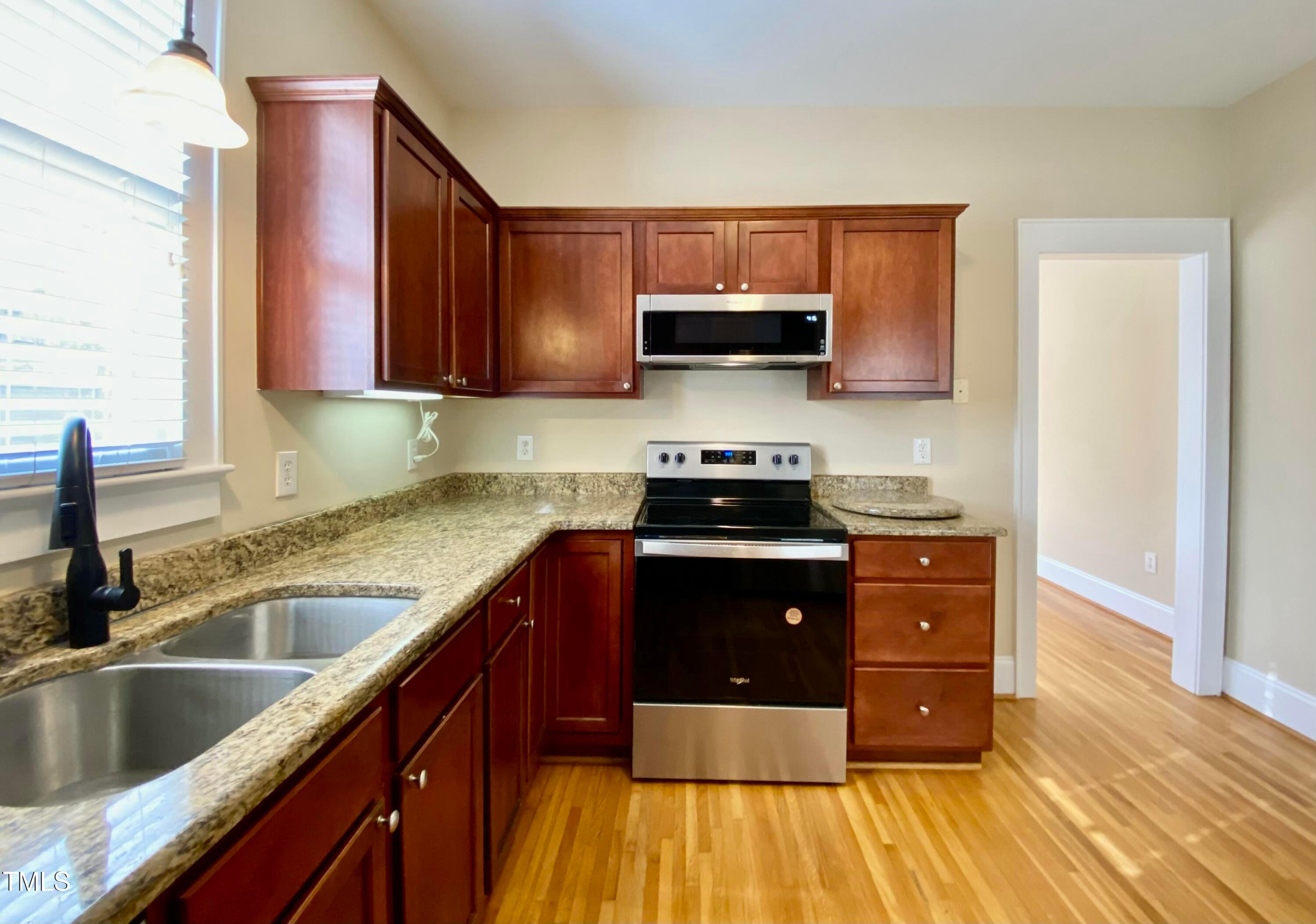 813 Clarendon Street Durham, NC 27705 - Photo 14 of 36 a kitchen with stainless steel appliances granite countertop a sink a stove and a microwave