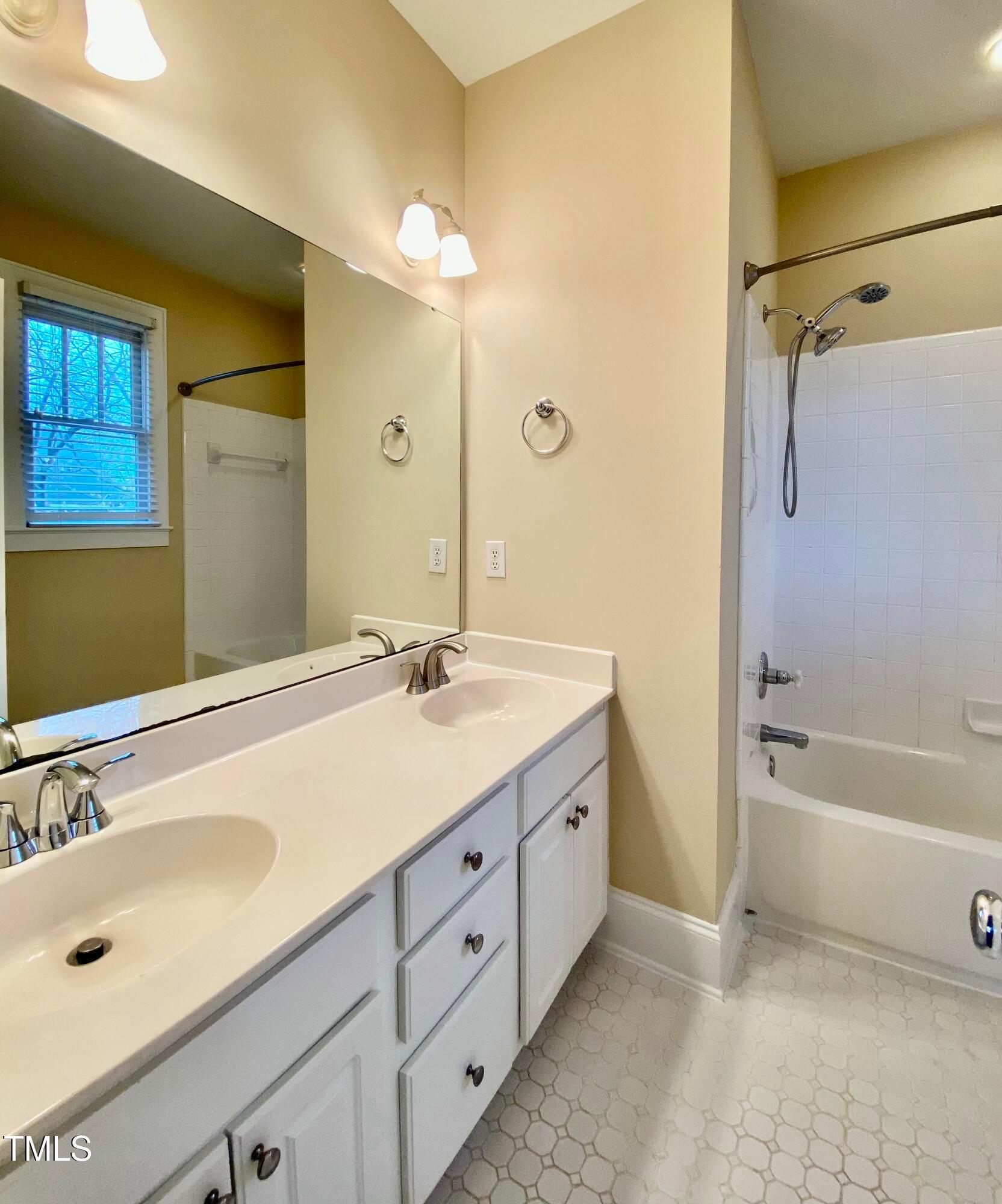 813 Clarendon Street Durham, NC 27705 - Photo 33 of 36 a bathroom with a tub sink double vanity and a mirror