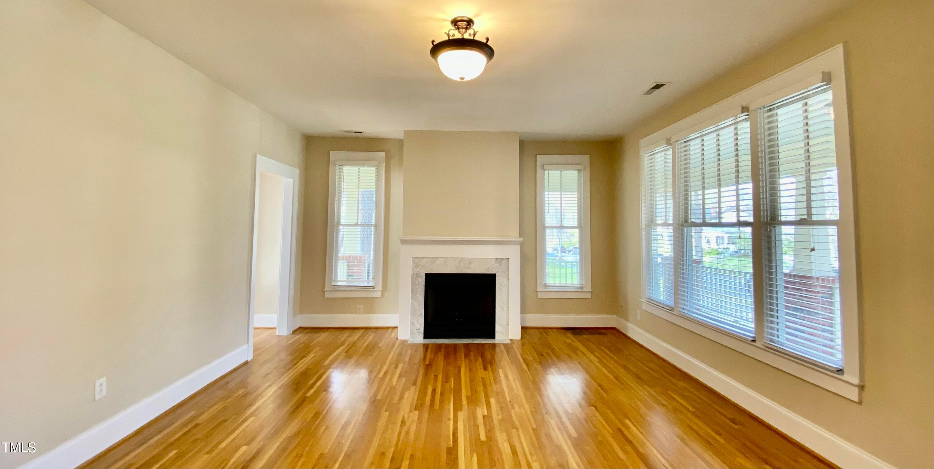813 Clarendon Street Durham, NC 27705 - Photo 7 of 36 a view of an empty room with wooden floor and a window