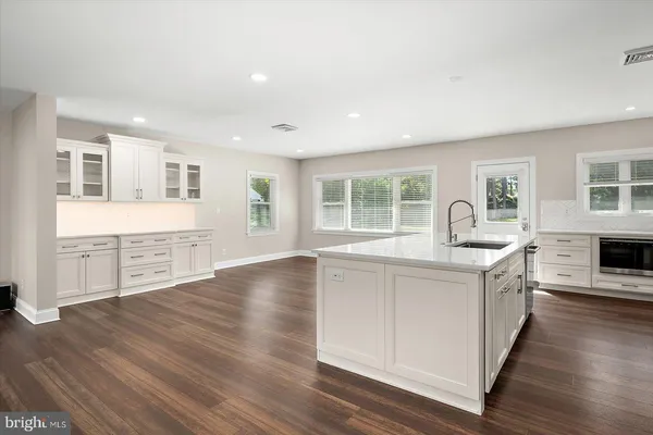 a kitchen with white cabinets stainless steel appliances and sink