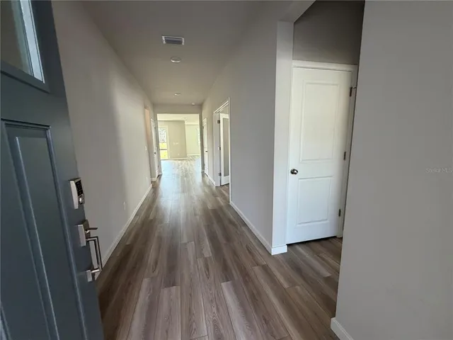 a view of a hallway with wooden floor