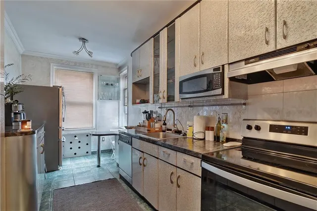 a kitchen with stainless steel appliances a sink a stove a microwave and cabinets