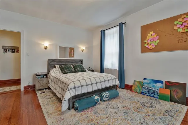 a bedroom with a bed and a wooden floor