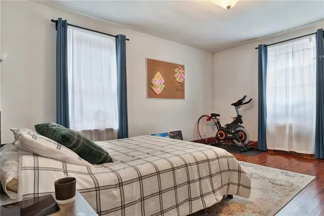 a bedroom with a bed and wooden floor