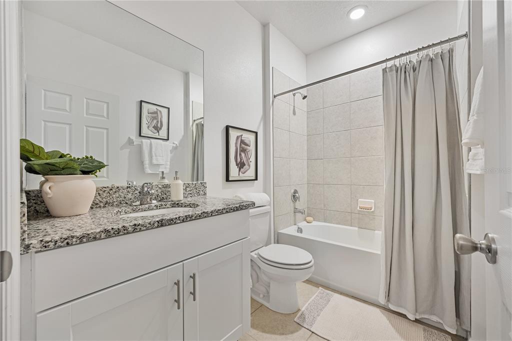 34217 Cinder Way Wesley Chapel, FL 33545 - Photo 18 of 27 a bathroom with a granite countertop sink toilet and shower