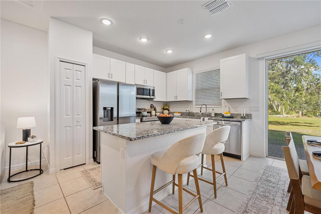 34217 Cinder Way Wesley Chapel, FL 33545 - Photo 4 of 27 a kitchen with stainless steel appliances granite countertop a stove a sink a refrigerator and a refrigerator