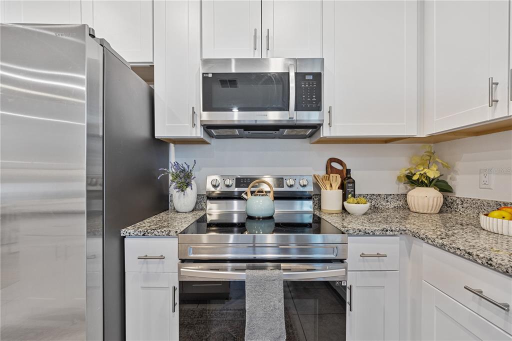 34217 Cinder Way Wesley Chapel, FL 33545 - Photo 5 of 27 a kitchen with a stove and a white cabinets