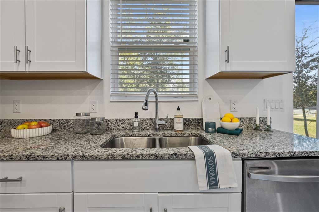 34217 Cinder Way Wesley Chapel, FL 33545 - Photo 6 of 27 a kitchen with granite countertop a stove a sink and a granite counter tops