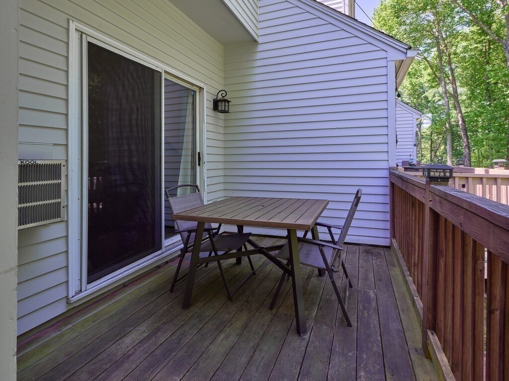 97 Riverview Place, Unit C Southbridge, MA 01550 - Photo 27 of 35 a view of a roof deck with table and chairs with wooden floor and fence