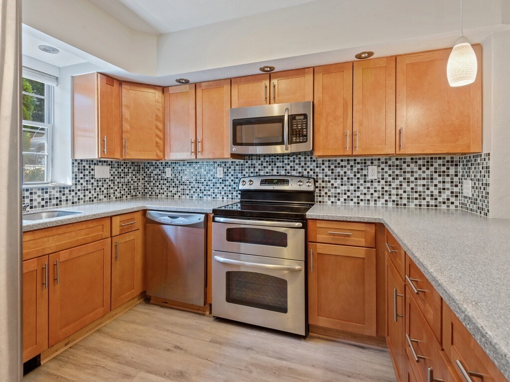 97 Riverview Place, Unit C Southbridge, MA 01550 - Photo 6 of 35 a kitchen with stainless steel appliances granite countertop a stove a sink and a microwave