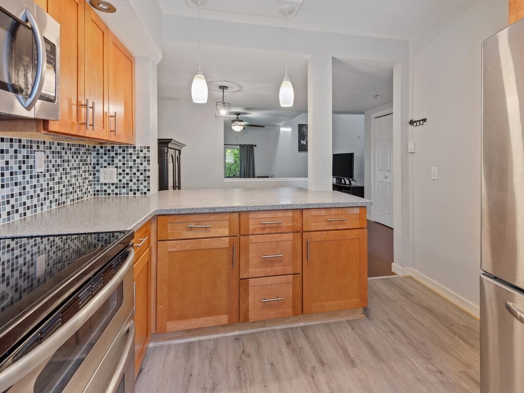 97 Riverview Place, Unit C Southbridge, MA 01550 - Photo 7 of 35 a kitchen with kitchen island granite countertop wooden cabinets and white appliances