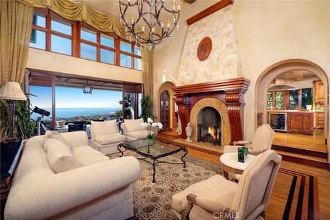 a living room with furniture a fireplace and a chandelier