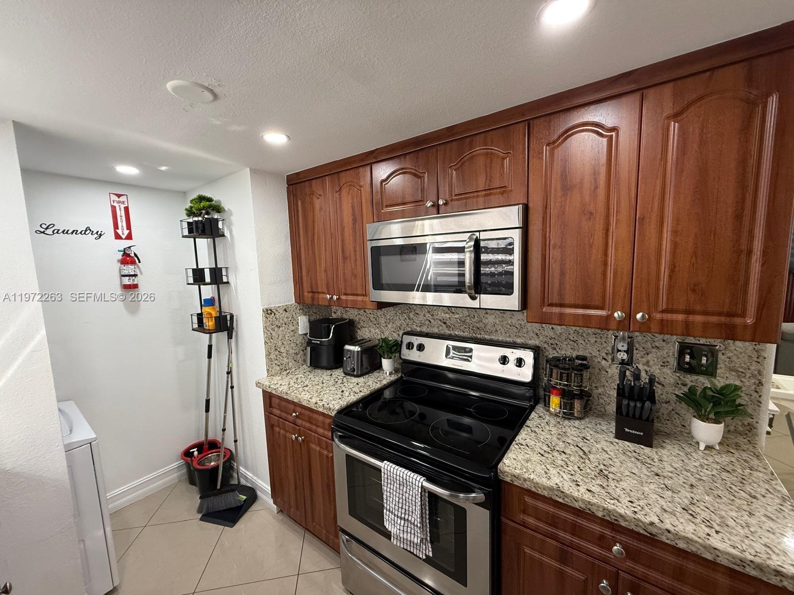 15445 Southwest 57th Street Miami, FL 33193 - Photo 21 of 78 a kitchen with stainless steel appliances granite countertop a sink stove and cabinets