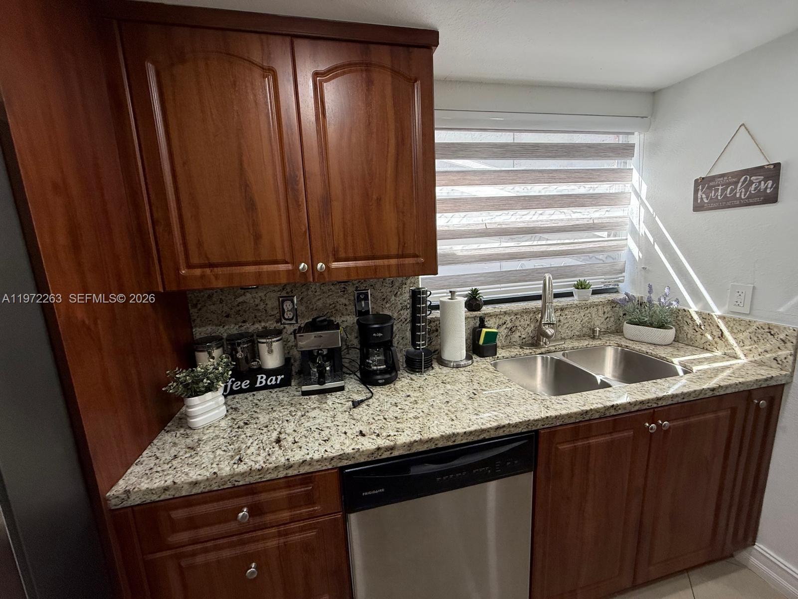 15445 Southwest 57th Street Miami, FL 33193 - Photo 22 of 78 a kitchen with granite countertop a sink a counter space and cabinets