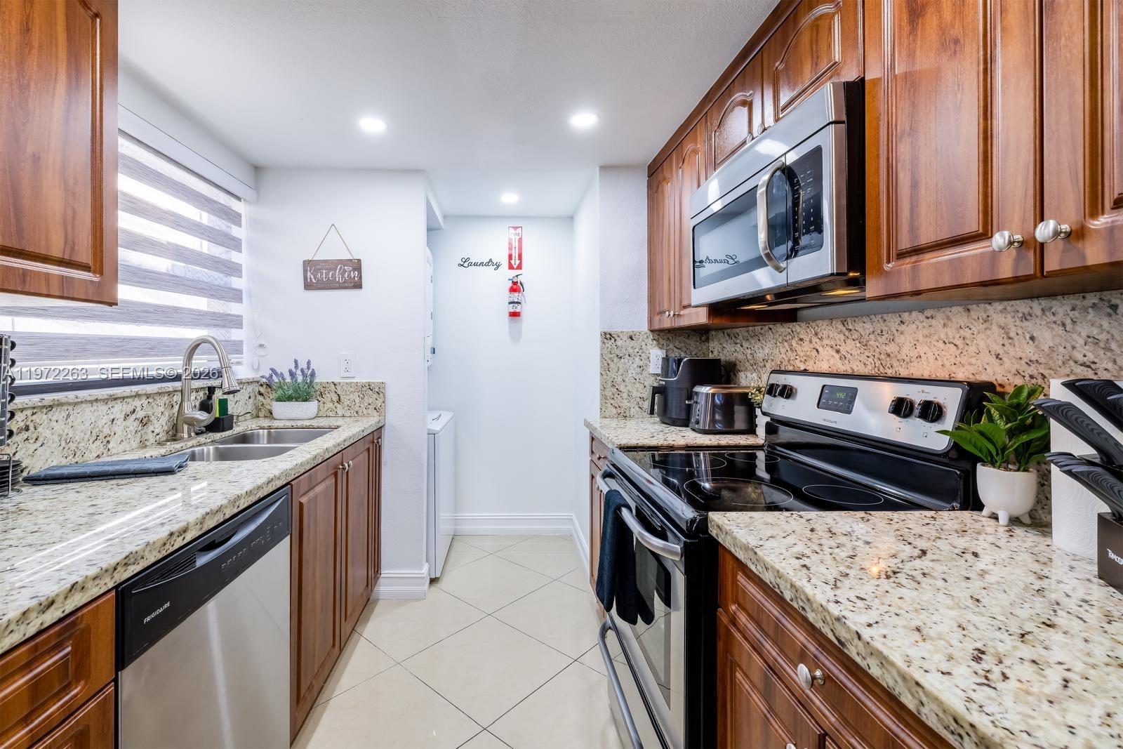 15445 Southwest 57th Street Miami, FL 33193 - Photo 23 of 78 a kitchen with stainless steel appliances granite countertop a stove a sink and a microwave