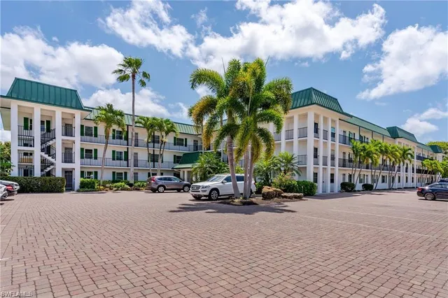 a row of palm trees in front of a building