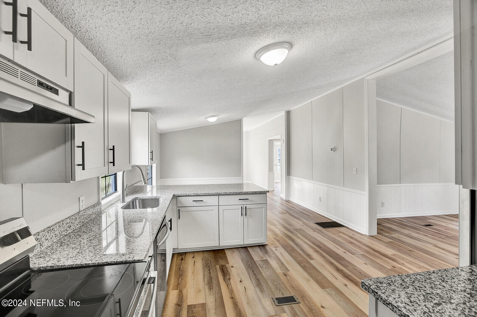 4016 Pinto Road Middleburg, FL 32068 - Photo 23 of 37 a large white kitchen with a sink and wooden floor