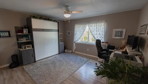a view of a hallway to a livingroom with furniture and workspace