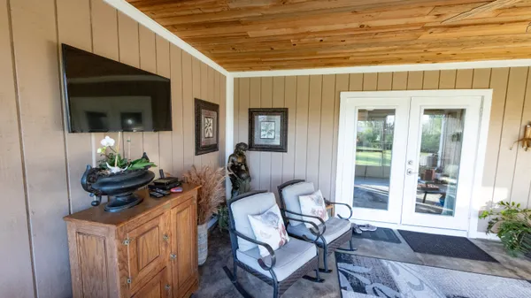 a view of a chair and table in backyard of the house