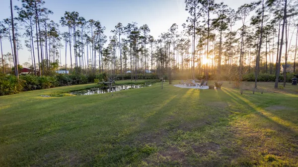 a living room with stainless steel appliances furniture a dining table wooden floor and a fireplace