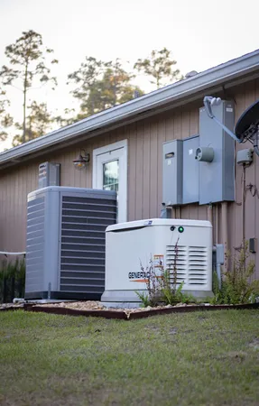 a backyard of a house with potted plants and large tree