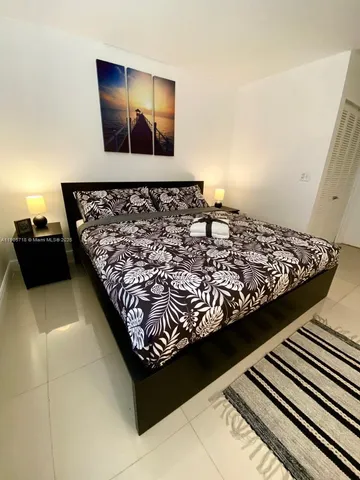 a bed sitting in a bedroom next to a lamp